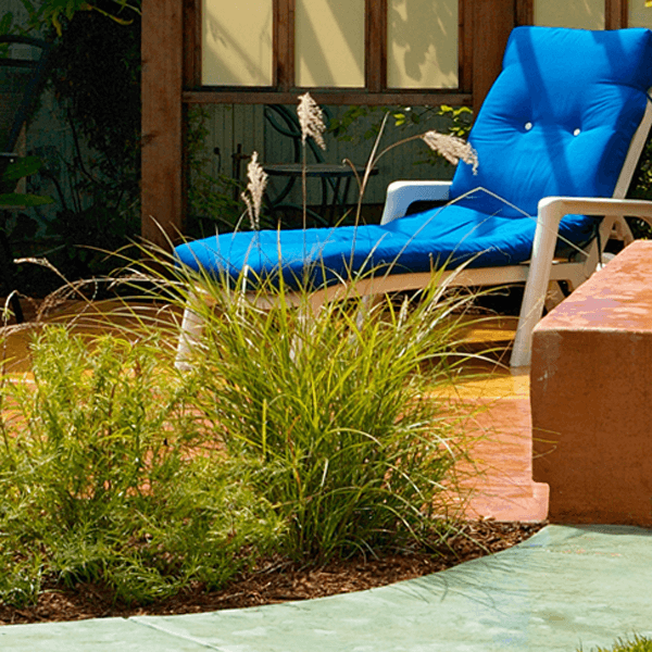 custom landscape garden design cement patio with blue chaise