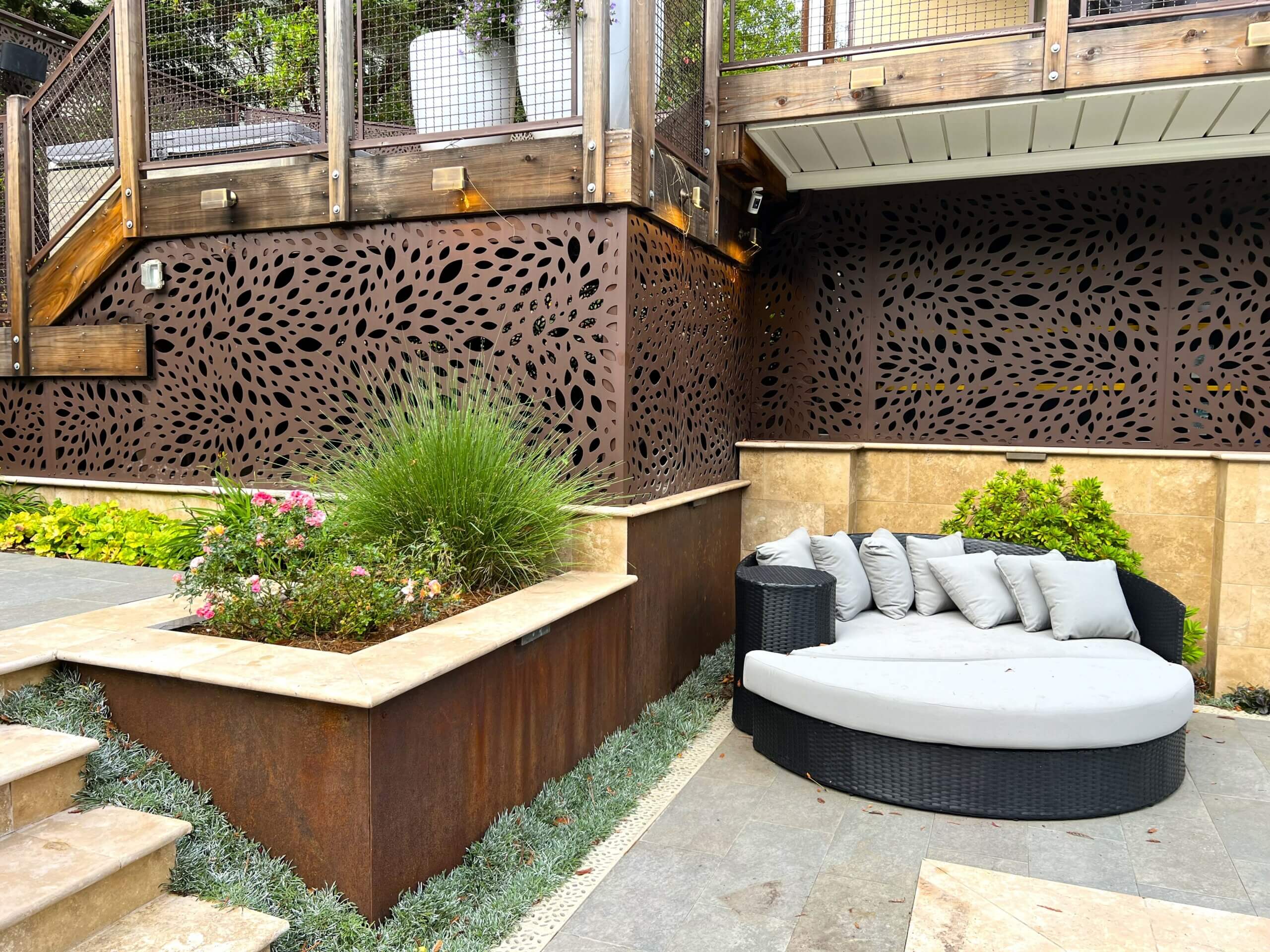 Complementary metal features in backyard landscape showing stamped metal screens and metal encased planter