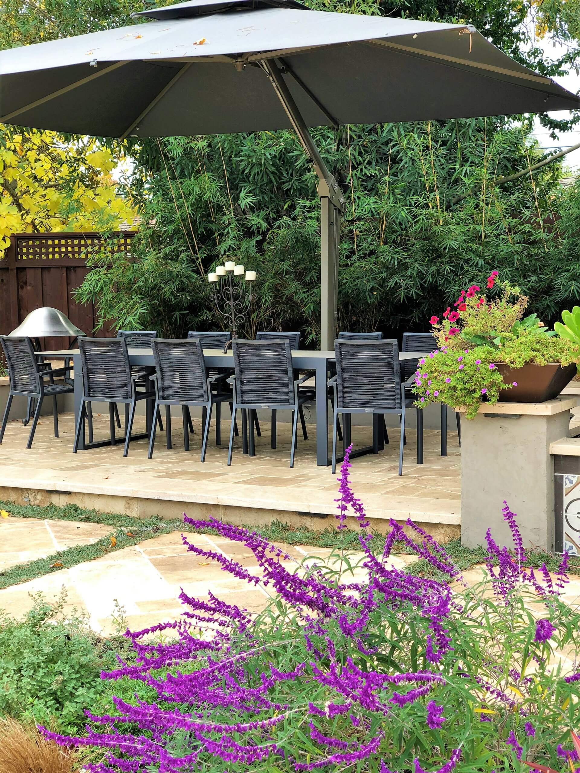 Outdoor dining area on umbrella covered paver raised patio