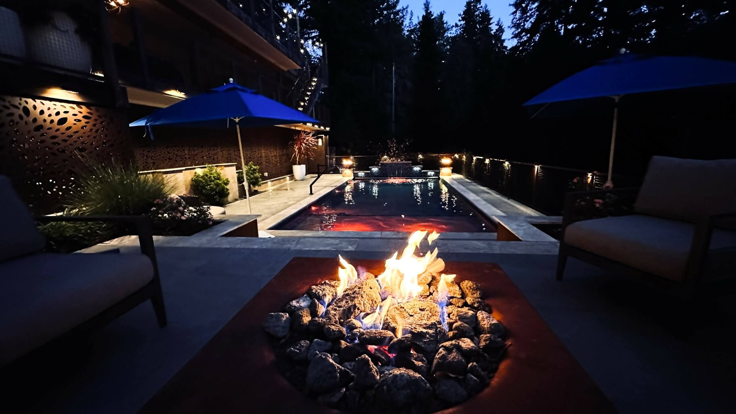 Firepit with swimming Pool at Night with Red Lights in the background
