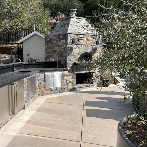 Large custom crafted outdoor kitchen with stone surround