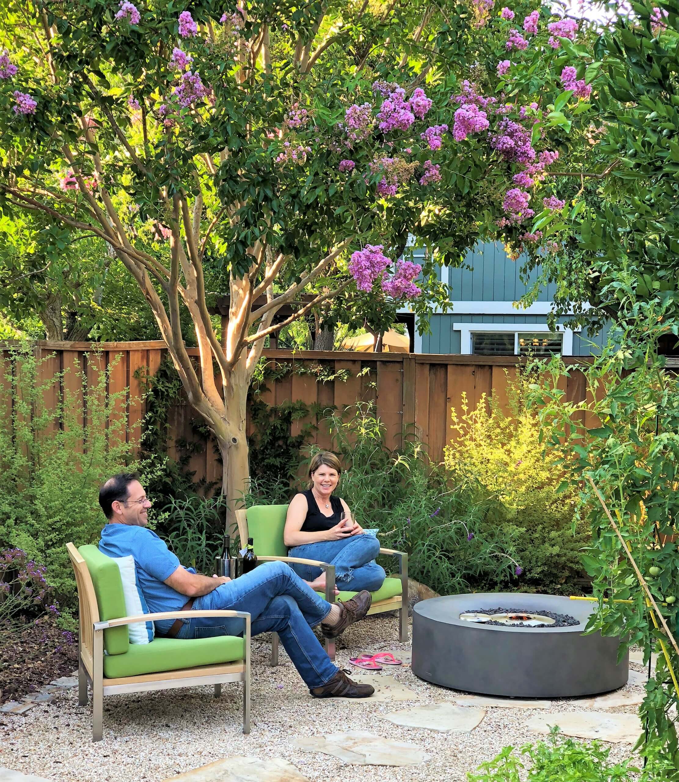 California couple sitting at fire pit in their relaxing back yard