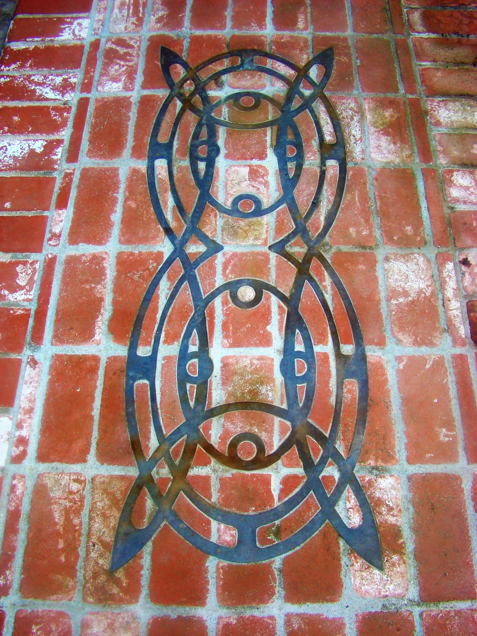Custom copper designed inlay in brick patio