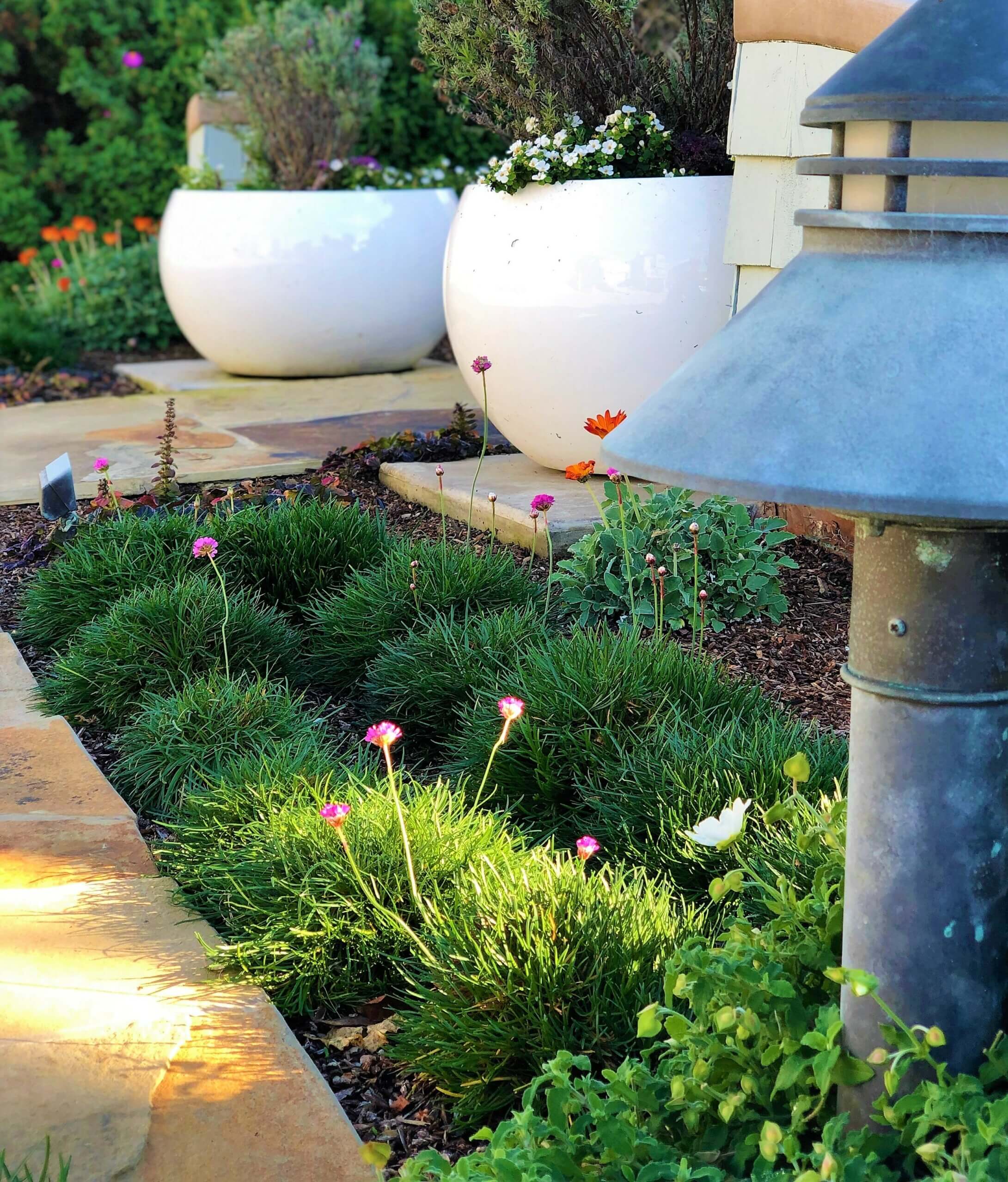 Pair of white potted planters next to metal garden lantern