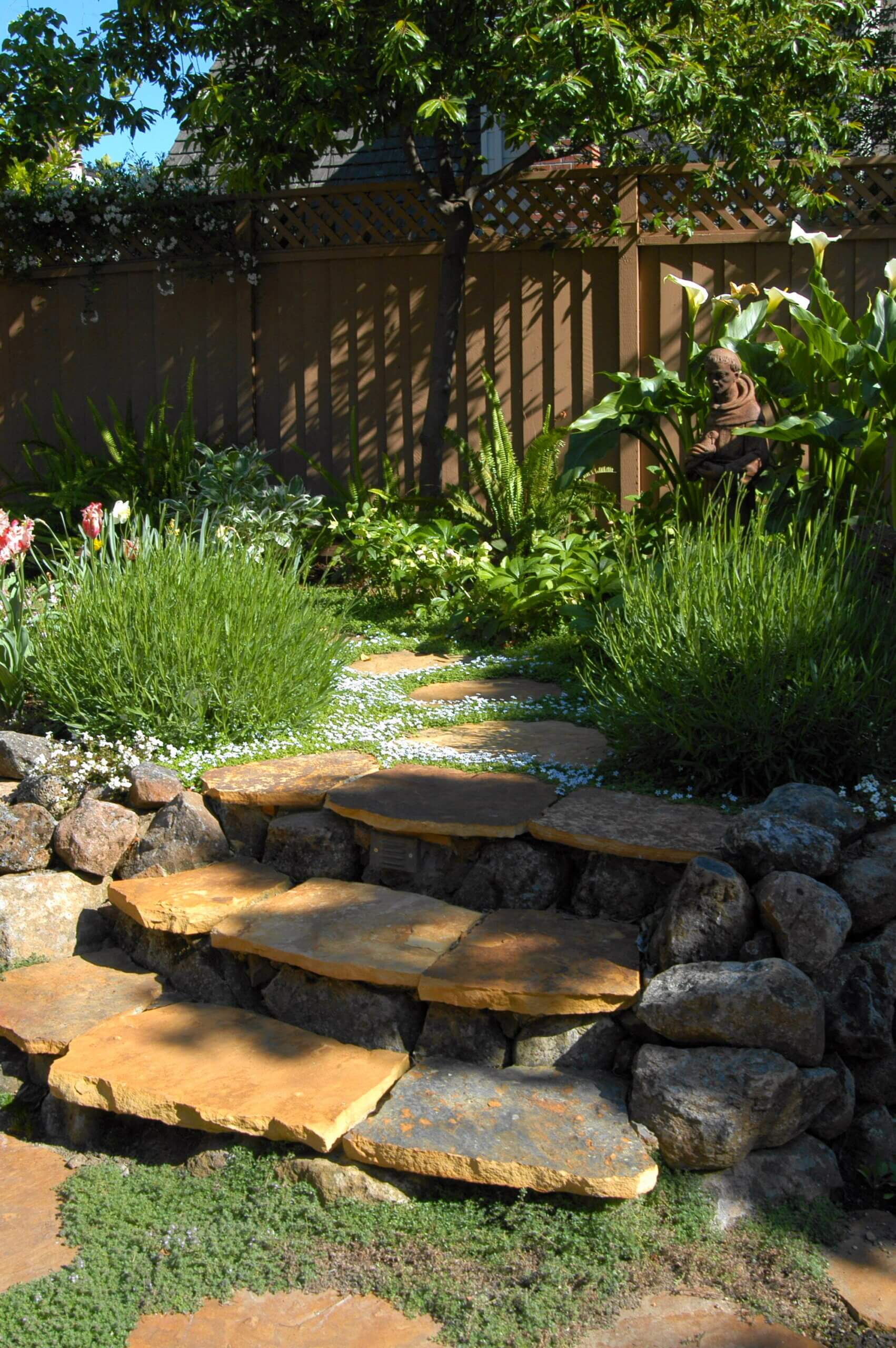 Stone steps and path interlaced with flowering ground cover and grasses