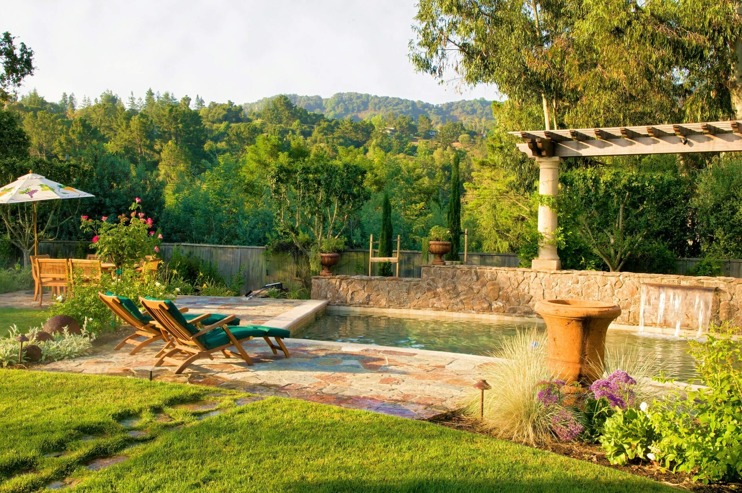 Natural paver and swimming pool with water feature and view of California hills