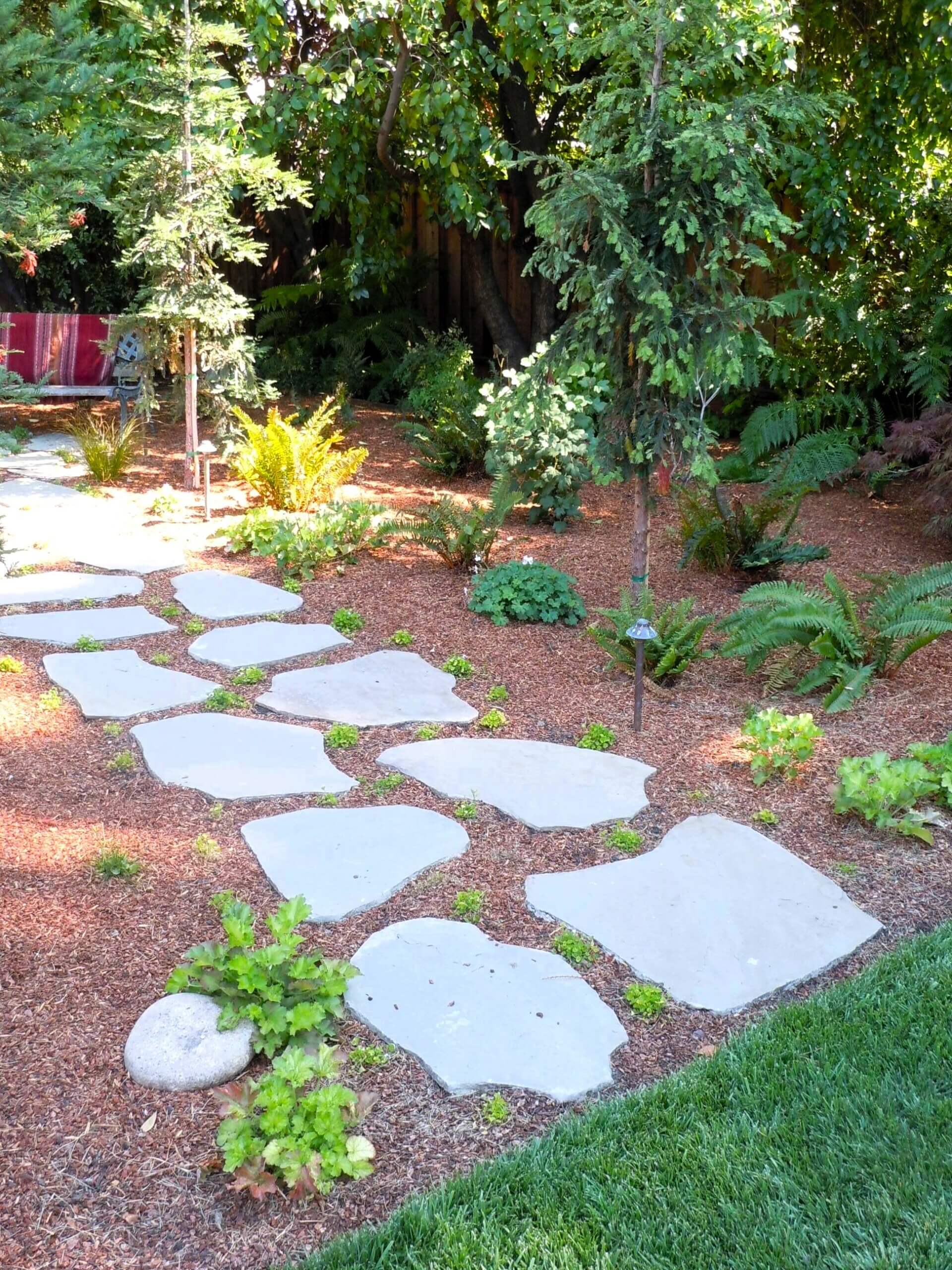 Natural sotne pavers in a wooded California backyard with manicured landscaping