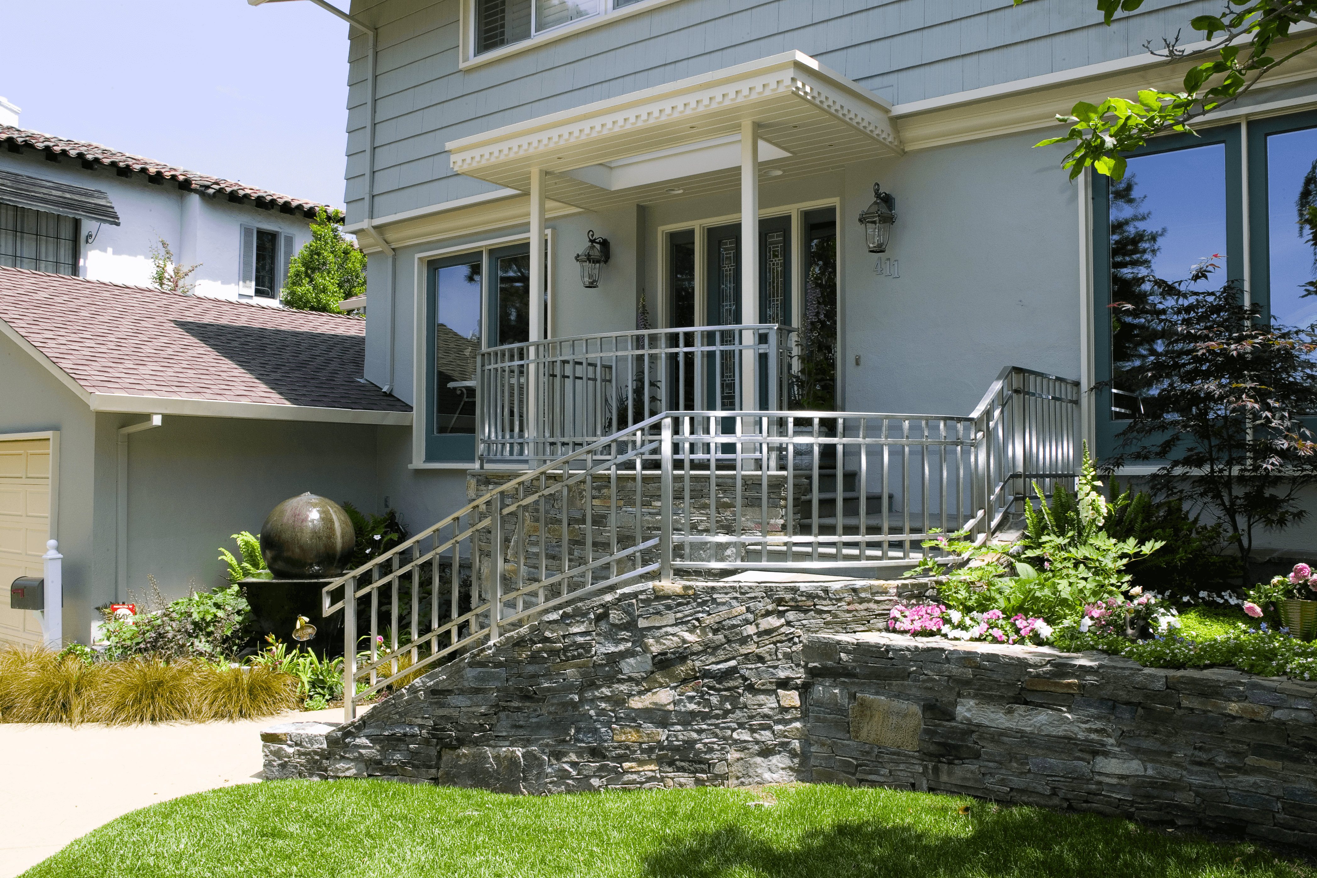 Stacked stone wall surrounding staircase leading to home front door