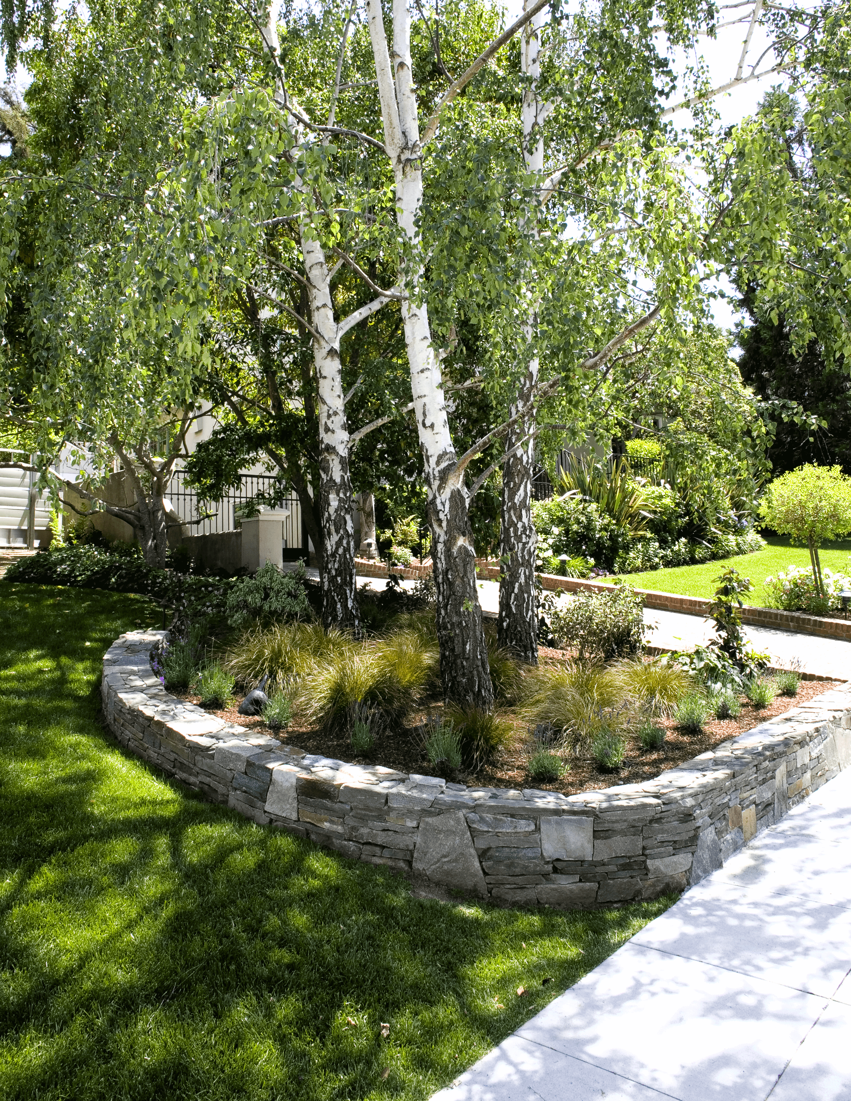Ornamental short stacked stone wall surrounding front yard