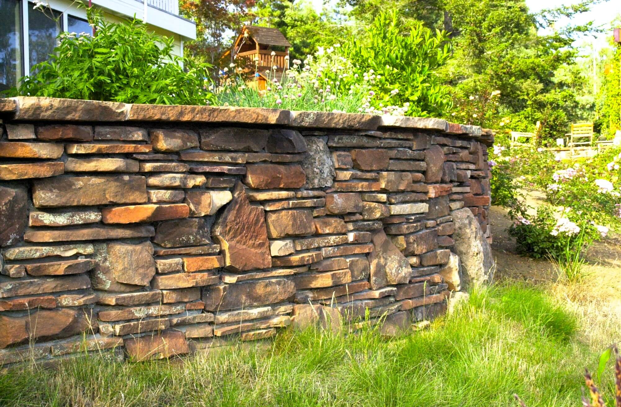 Backyard landscape retaining wall made from flat stacked stone