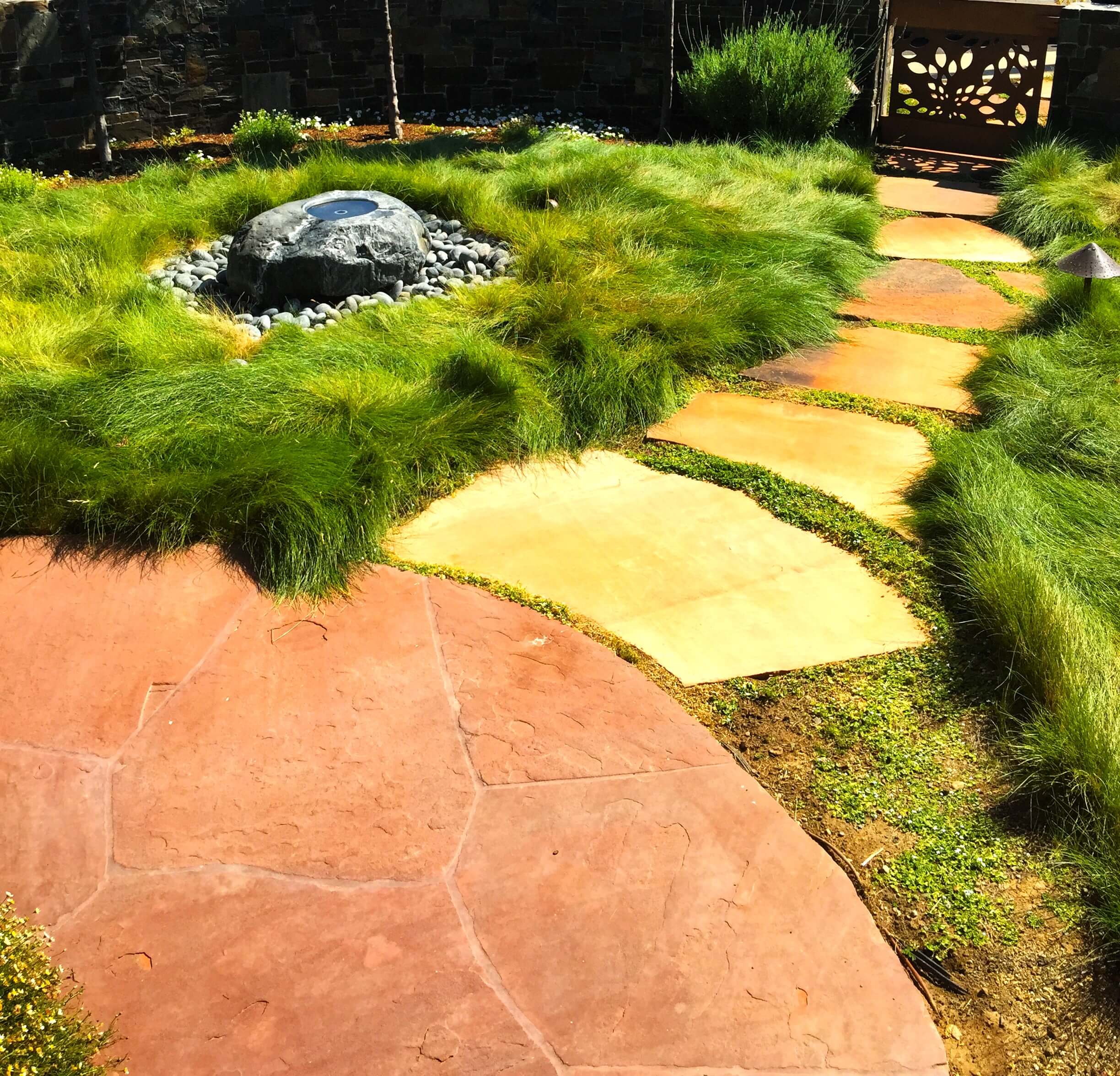 Paver stone walkway amidst tall ornamental grass