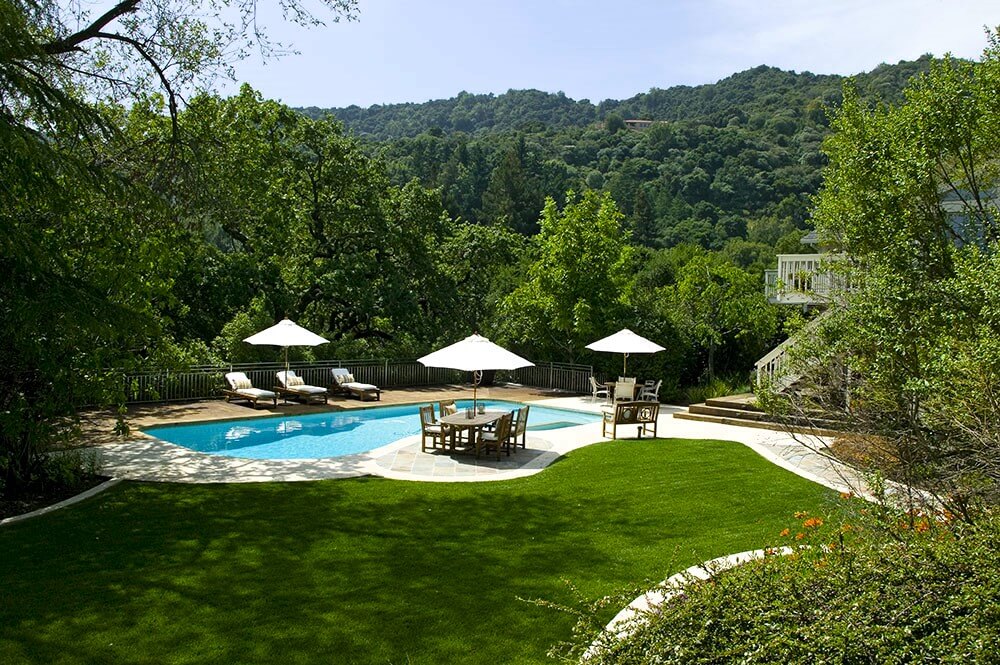Swimming pool at edge of backyard hillside with amazing view of lush northern California hillside.