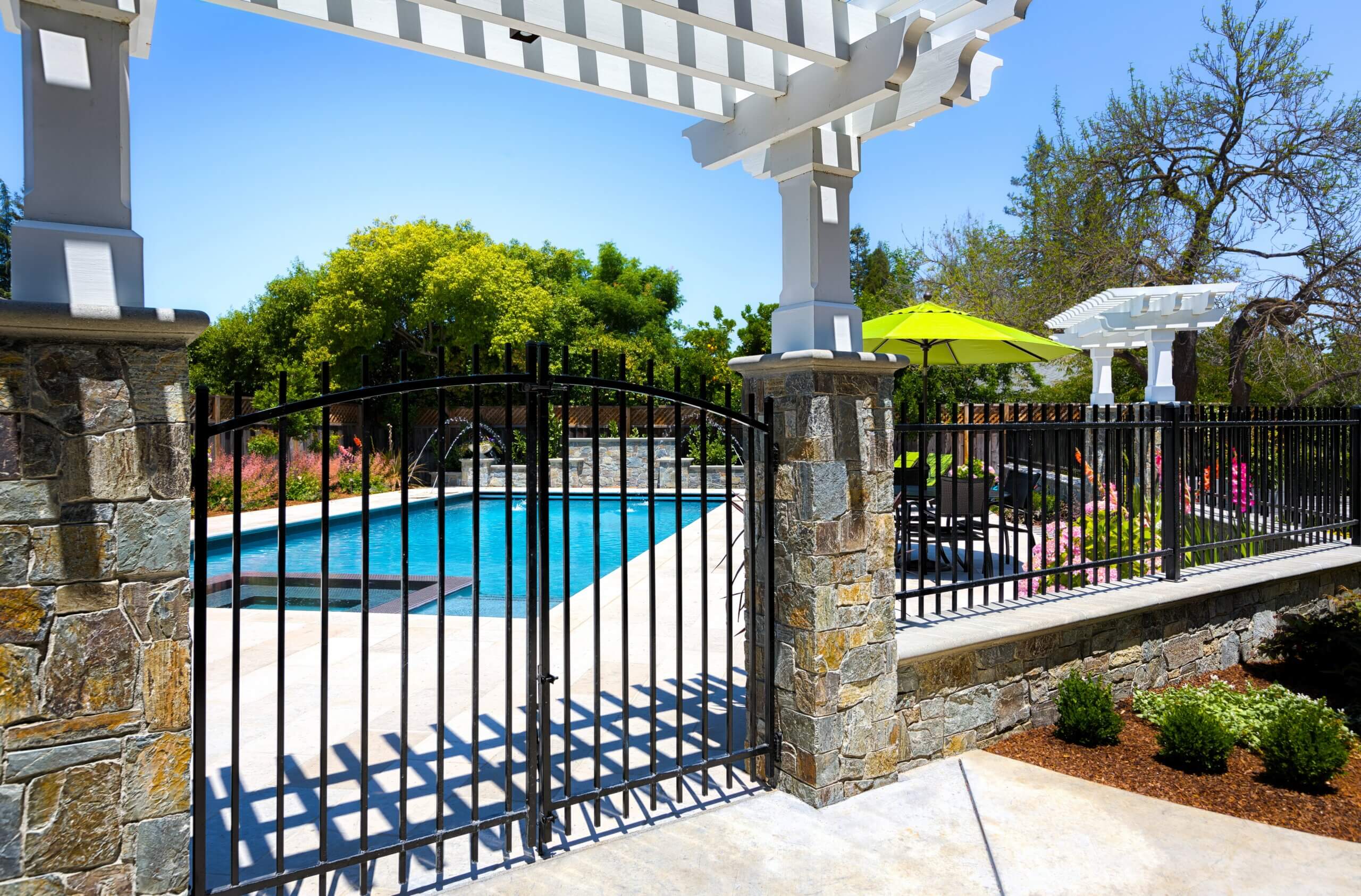 Large family swimming pool protected by large custom iron safety fence