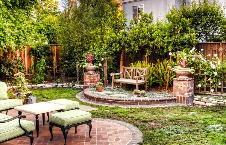 Two backyard seating areas on curved brick custom patios