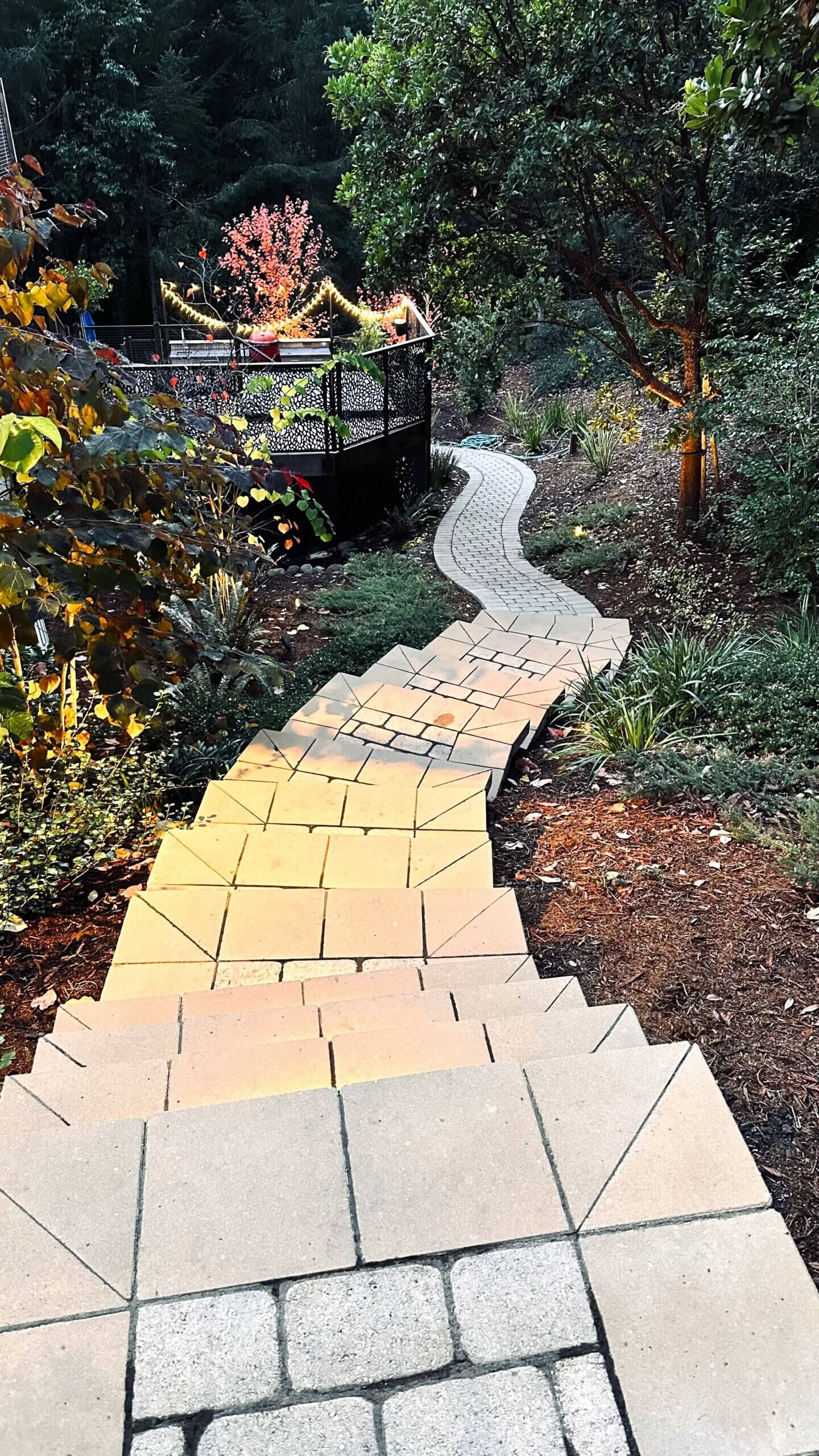 Paver stairs leading down side yard on a steep slope