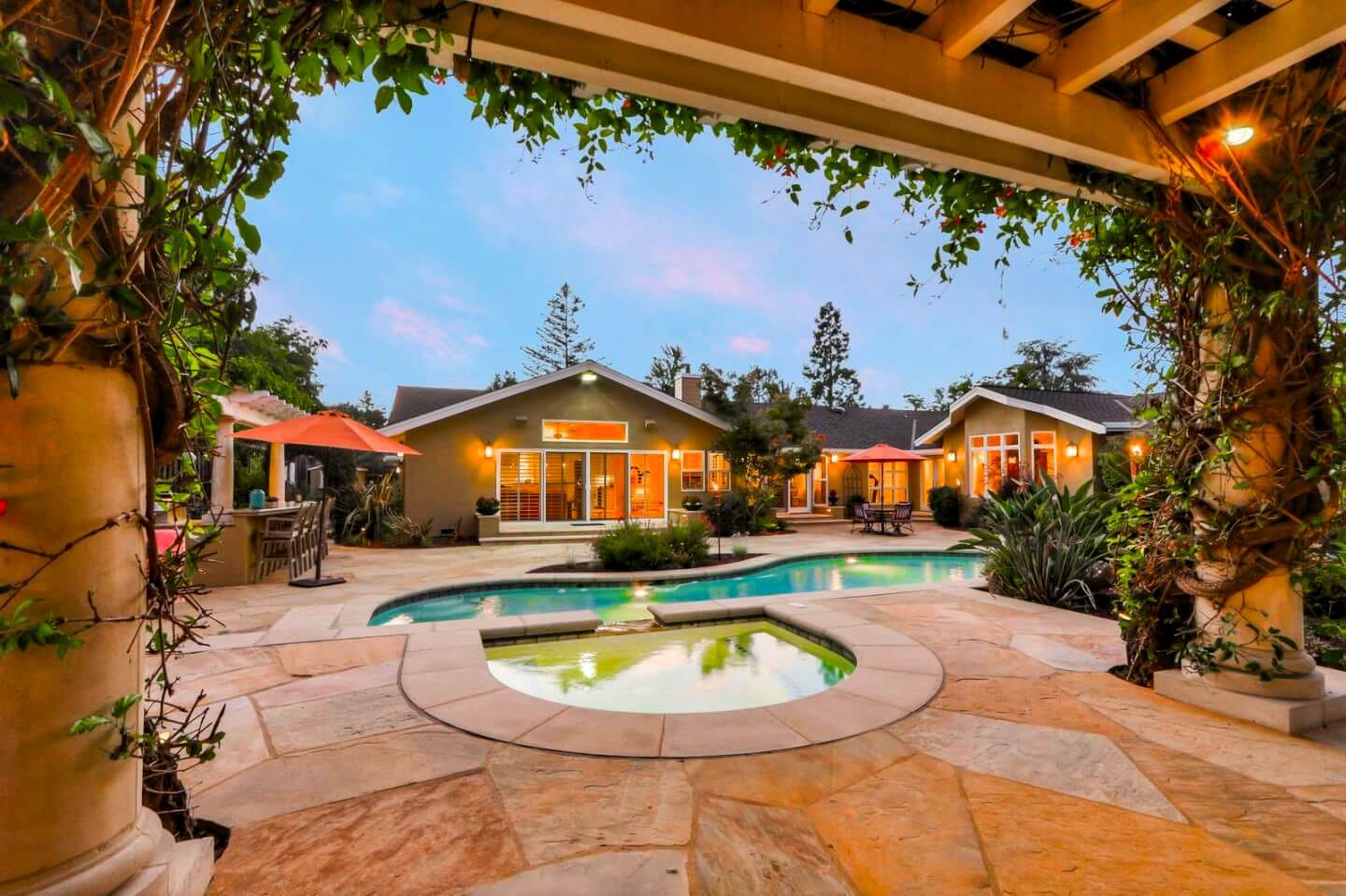 Hot tub at night with view of gorgeous backyard swimming pool and flagstone paver patio of beautiful California home