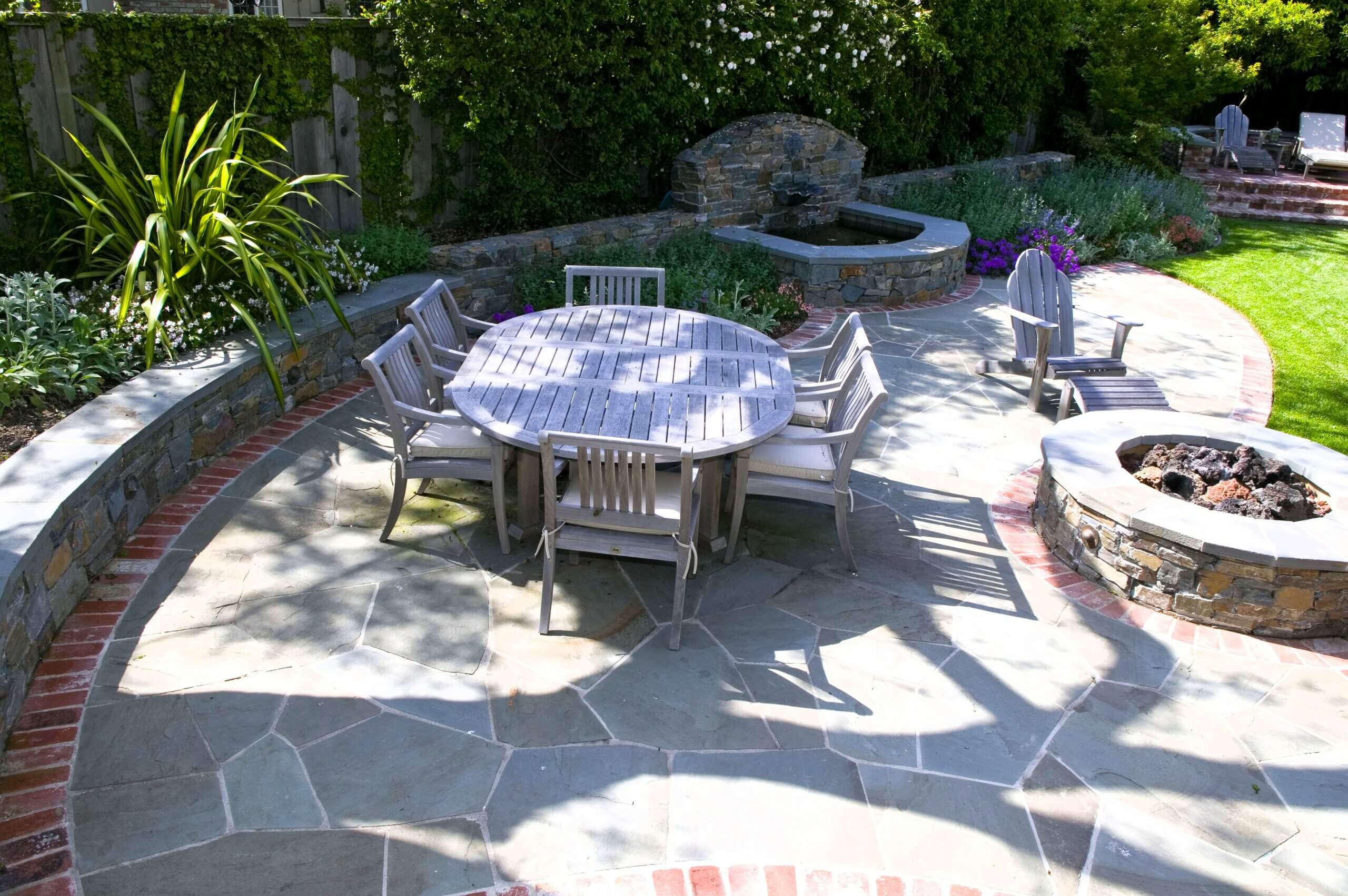 Brick and stone curved dining patio in California landscaped backyard